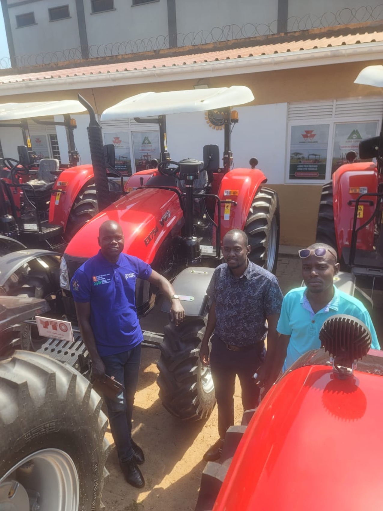 The visiting NUTOFA team standing beside one of the tractors at Agro Corner
